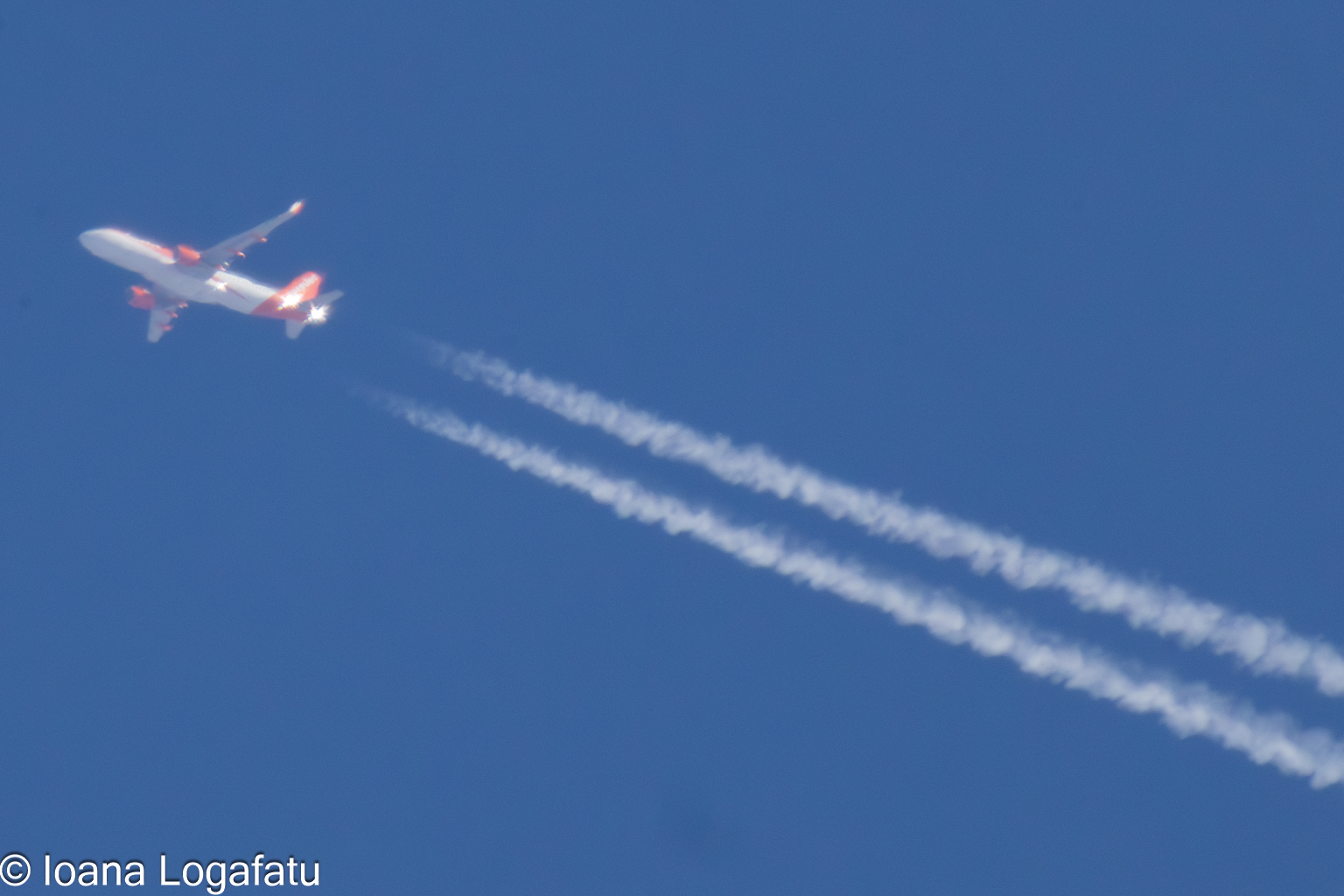 Airplane soaring high, leaving trails in the sky